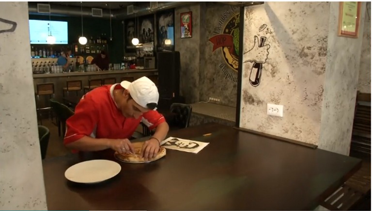 طاهٍ يستخدم صورتي سواريز ورونالدو للترويج للبيتزا بمطعمه