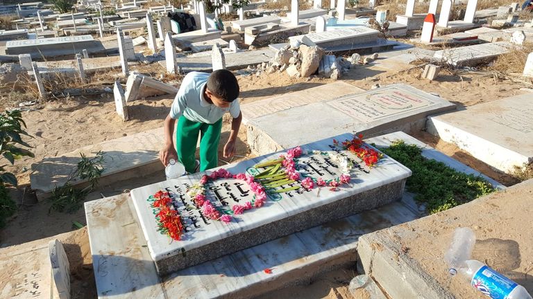 أحد أبناء الشهداء يضع زهورا على قبر شهيد الكنيست الإسرائيلي- أرشيفية