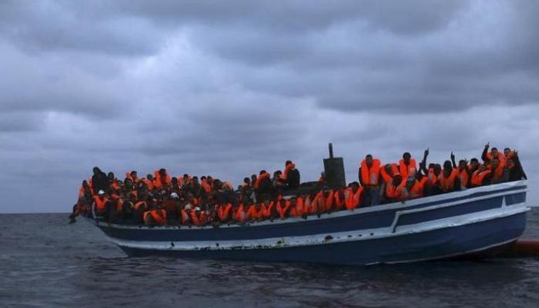 سفينية صغيرة تقل مهاجرين في البحر - أرشيفية الشرطة تصطحب المهاجرين من على السفينة- أ.ف.ب