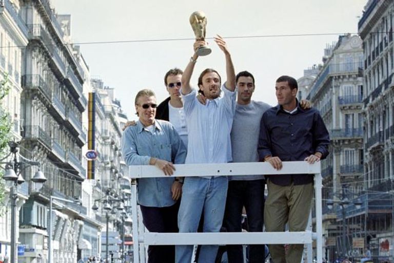 دوجاري يرفع كأس العالم 1998 وبجواره ديشامب ونجوم فرنسا ديشامب - مدرب منتخب فرنسا