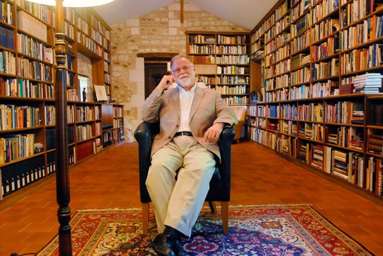 ألبرتو مانغويل في مكتبته الخاصة غلاف كتاب "الفضول"