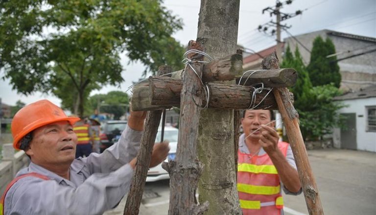 عمال يحاولون إصلاح الأضرار التي تسبب بها الإعصار قوارب وسفن في الصين