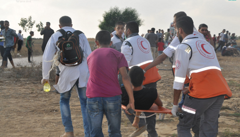 طواقم الإسعاف الفلسطيني تحمل مصابا خلال مواجهات غزة