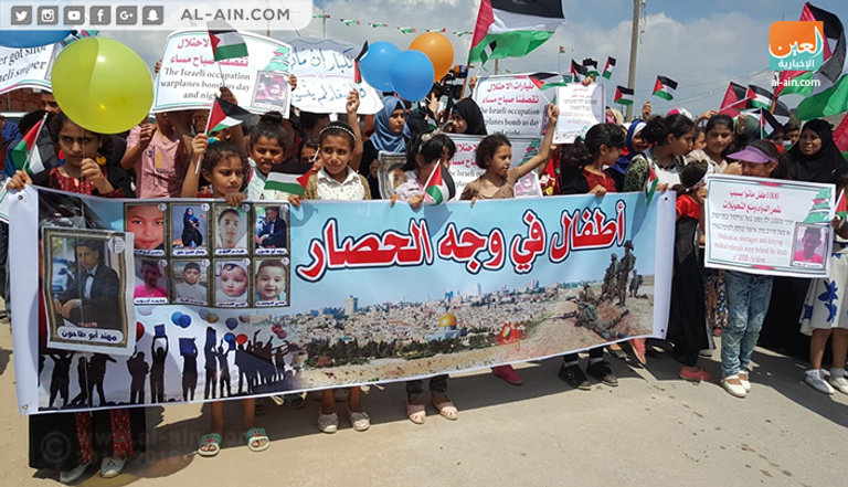 الأطفال خلال مشاركتهم في مسيرة للتنديد بالحصار