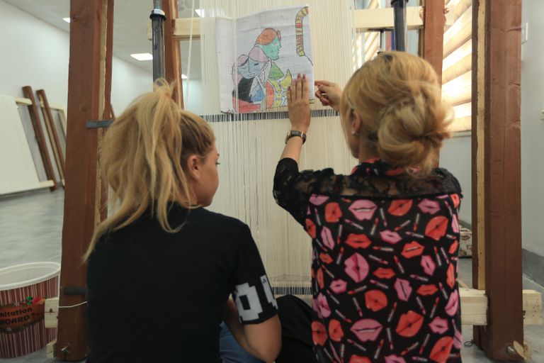 مصنع سجاد يغزل أحلام إيزيديات العراق في "لقمة عيش" نساء إيزيديات يعملن في مصنع للسجاد بدهوك العراقية