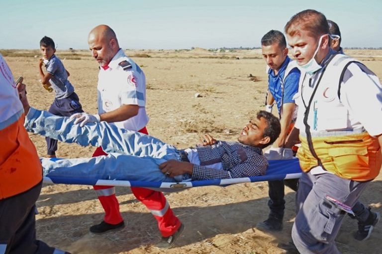 شباب يرفعون العلم الفلسطيني خلال إحياء فعاليات مسيرات العودة بغزة