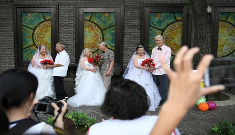 مسنون صينيون بملابس الزفاف في عيد الحب