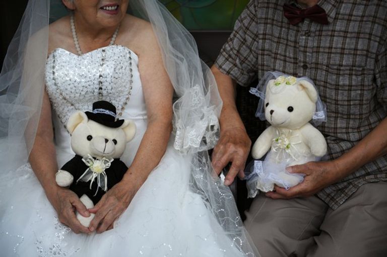 مسنون صينيون بملابس الزفاف في عيد الحب