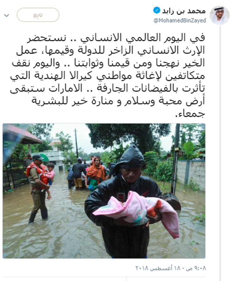 أحد المتضررين من فيضان كيرلا يحمل طفله وسط المياه