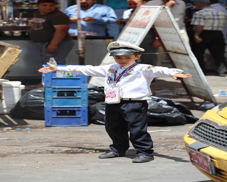 بالصور.. "العين الإخبارية" ترصد تجربة 3 أطفال لحل أزمة المرور ببغداد