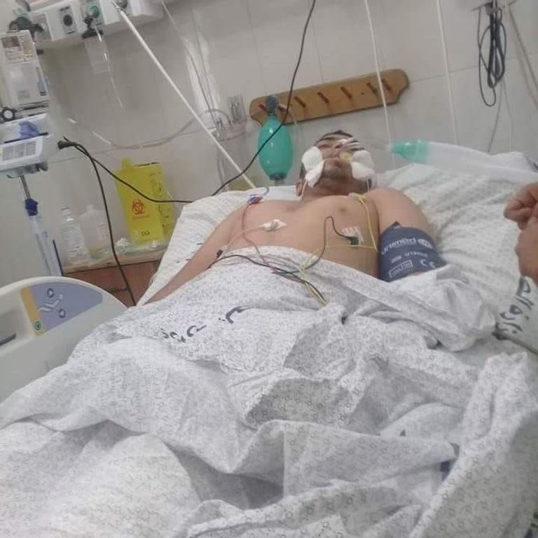 الشهيد هو أمجد فايز حمدونة خلال تلقي العلاج  العلم الفلسطيني مرفوع خلال حشد من الفلسطينيين أثناء مسيرات العودة