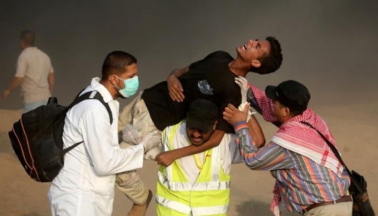 رجال الإسعاف يحملون فلسطينياً مصاباً- رويترز