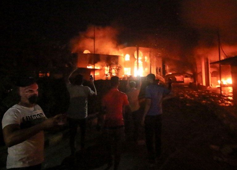 النيران تلتهم القنصلية الإيرانية في البصرة شاب عراقي يحرق العلم الإيراني خلال مظاهرات البصرة - أ.ف.ب