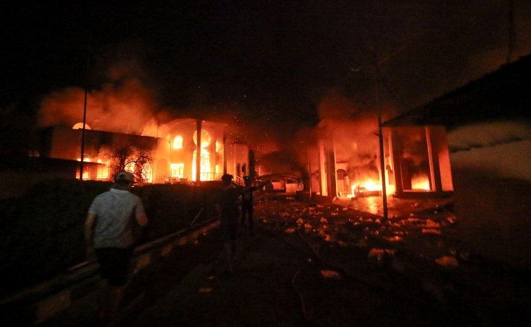 النيران تلتهم القنصلية الإيرانية في البصرة شاب عراقي يحرق العلم الإيراني خلال مظاهرات البصرة - أ.ف.ب