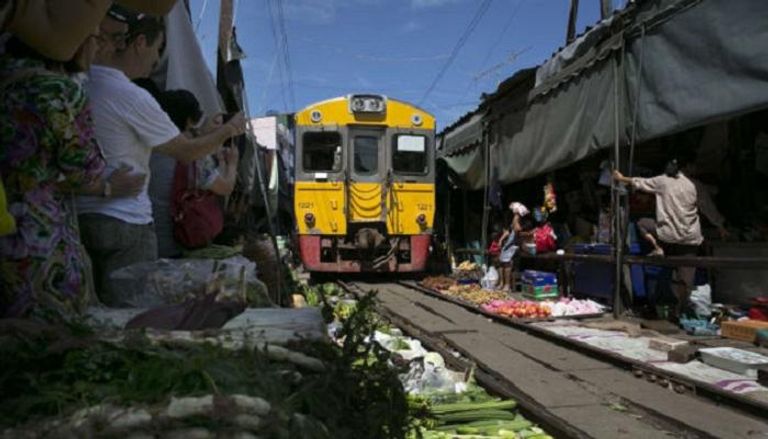 القطار يمر عبر زقاق السوق التايلاندية الشعبية 8 مرات يوميا