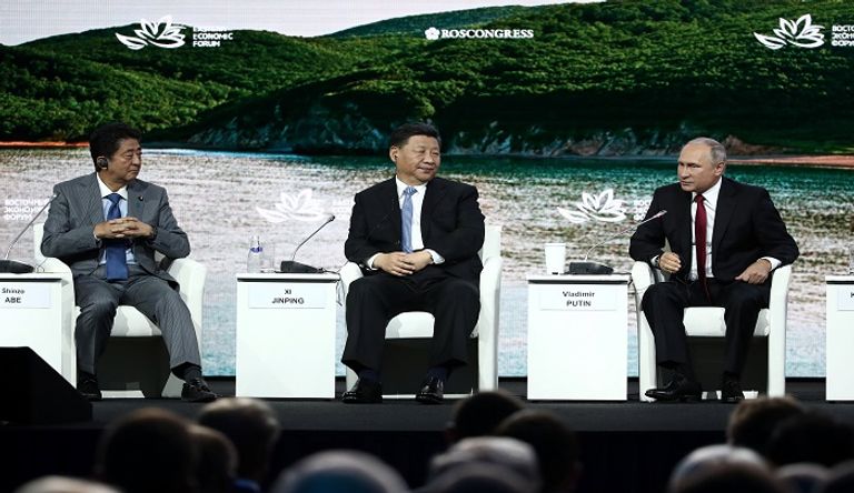 من اليمين بوتين والرئيس الصيني ورئيس الوزراء الياباني- رويترز