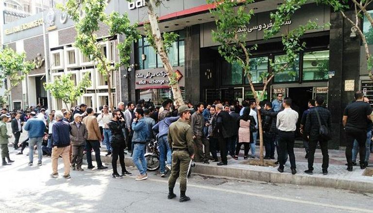 إيرانيون يبحثون عن الدولار أمام مكتب صرافة 