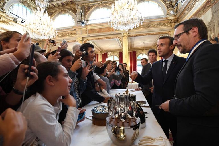 الرئيس الفرنسي إيمانويل ماكرون يصافح زوار قصر الإليزيه