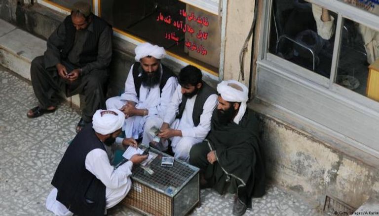 تجار أفغان يعدون العملات في سوق المال بهرات