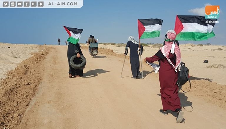 جانب من المسيرة رجال الإسعاف يحملون مصابا فلسطينيا برصاص الاحتلال