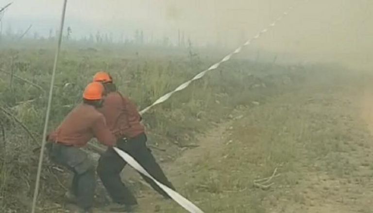 رجال الإطفاء يجذبون الخرطوم من قلب الإعصار