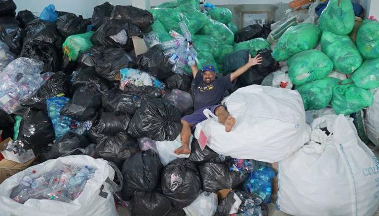حسام حمدي بين أكوام النفايات التي جمعها