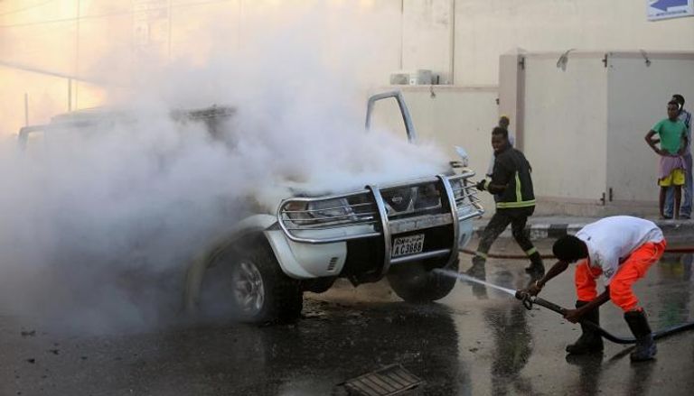 محاولة إطفاء إحدى السيارتين الملغومتين بعد انفجارها - رويترز