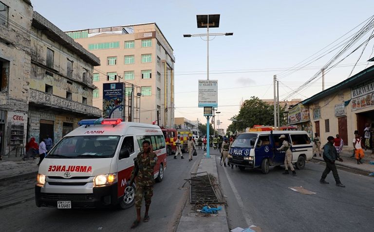 سيارة إسعاف تصل إلى مكان الانفجار في مقديشو محاولة إطفاء إحدى السيارتين الملغومتين بعد انفجارها - رويترز