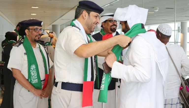 شرطة أبوظبي تستقبل السعوديين بالورود والأعلام احتفاء بيومهم الوطني 