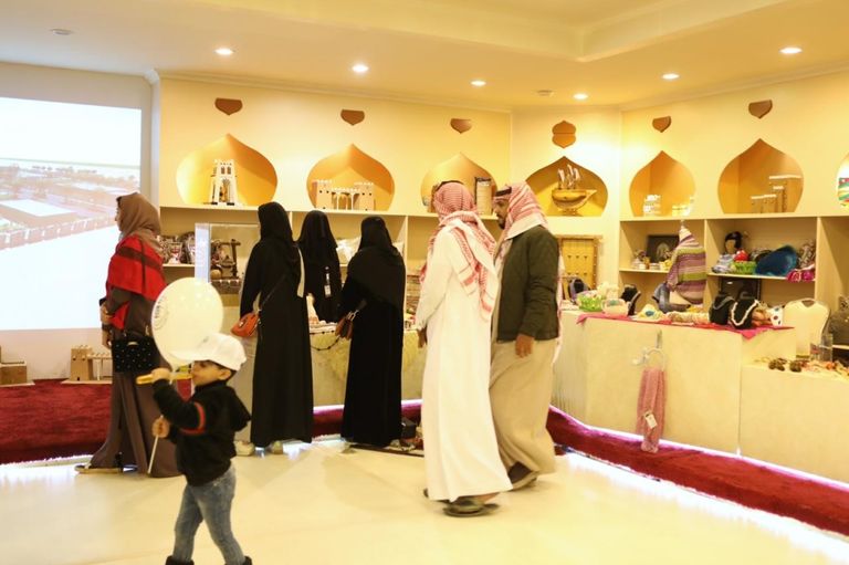 بعض زوار مهرجان الجنادرية يتفقدون جناح منتجات نزيلات السجون السعودية