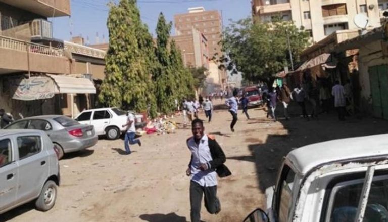 متظاهرون سودانيون يفرون من قنابل الغاز المسيل للدموع
