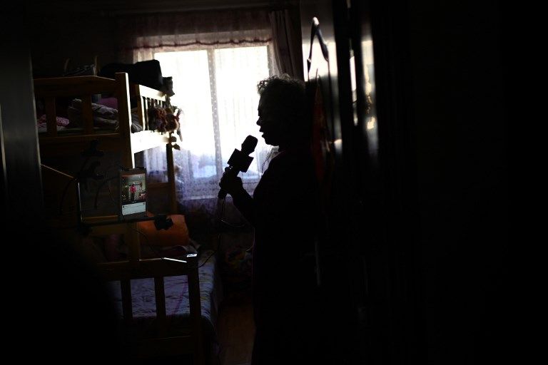 مسنة صينية تستخدم هاتفها الذكي خلال الغناء