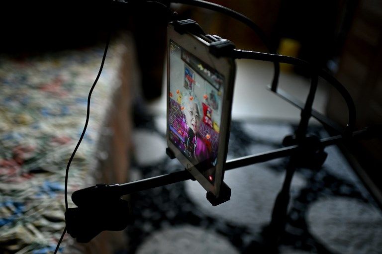 مسنة صينية تستخدم هاتفها الذكي خلال الغناء