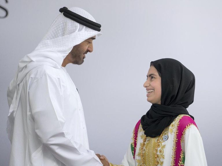 الطالبة فاطمة الكعبي تجري تجاربها على روبوت