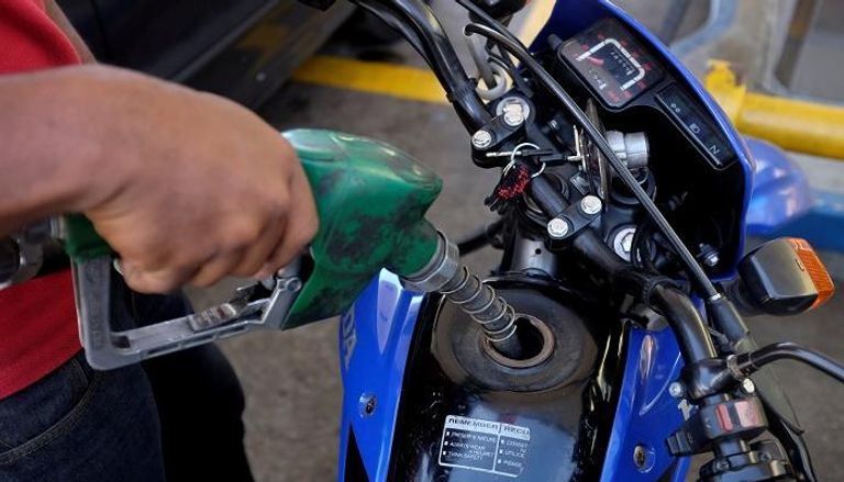 عامل يضخ الوقود إلى دراجة نارية في فنزويلا - رويترز