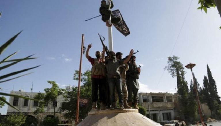 عناصر جبهة النصرة يرفعون علم التنظيم الإرهابي في قرية بإدلب - أرشيفية