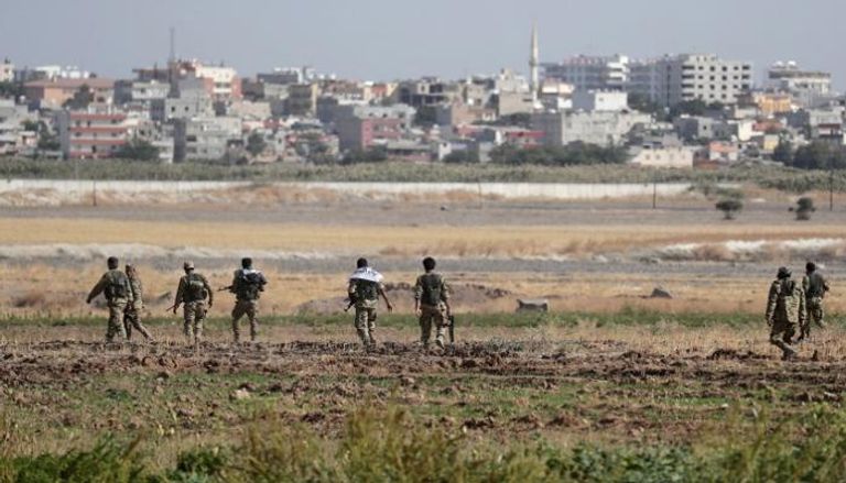 عناصر مسلحة تركية خلال هجوم على بلدة حدودية سورية - رويترز