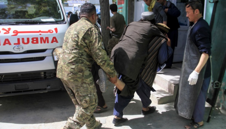 أفراد أمن أفغان يحملون رجلا مصابا إلى مستشفى إثر هجوم انتحاري
