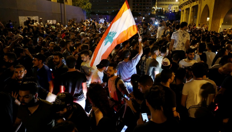 متظاهر يحمل العلم اللبناني خلال احتجاج في بيروت- رويترز