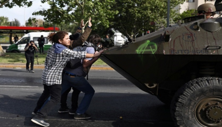المحتجون في مواجهة مدرعة أمنية في تشيلي - رويترز