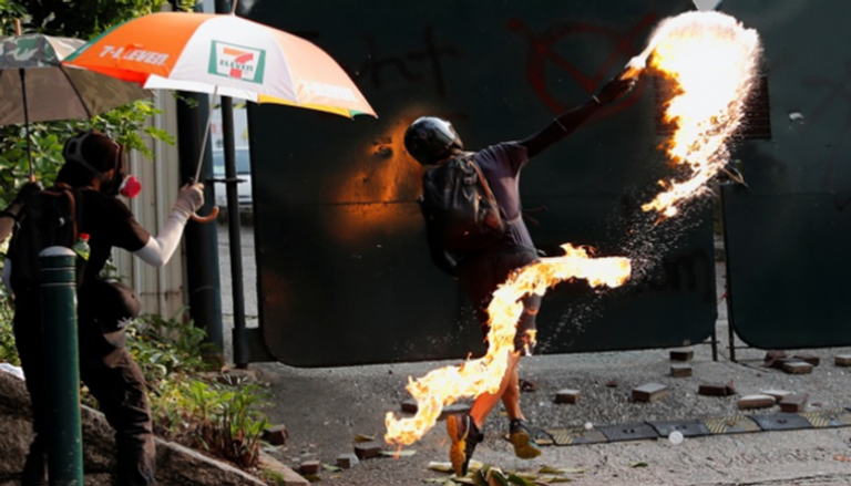 متظاهر في هونج كونج يلقي مادة حارقة على الشرطة - رويترز
