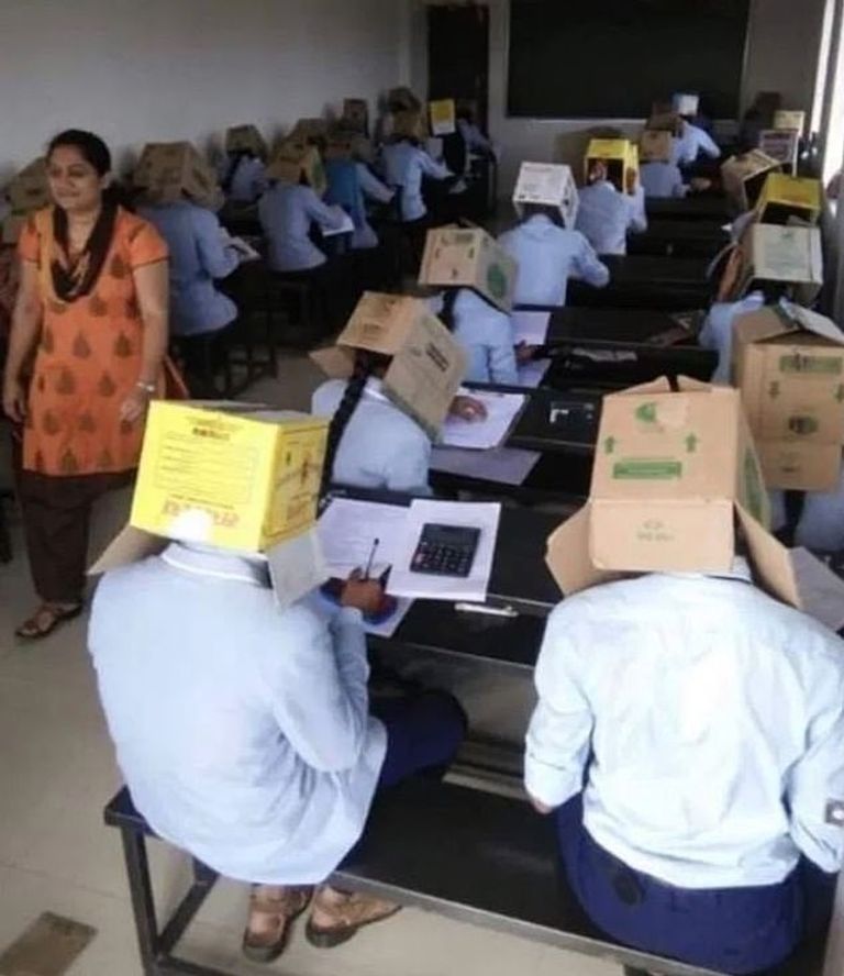 طلاب يضعون صناديق فوق رؤوسهم خلال أداء الامتحان