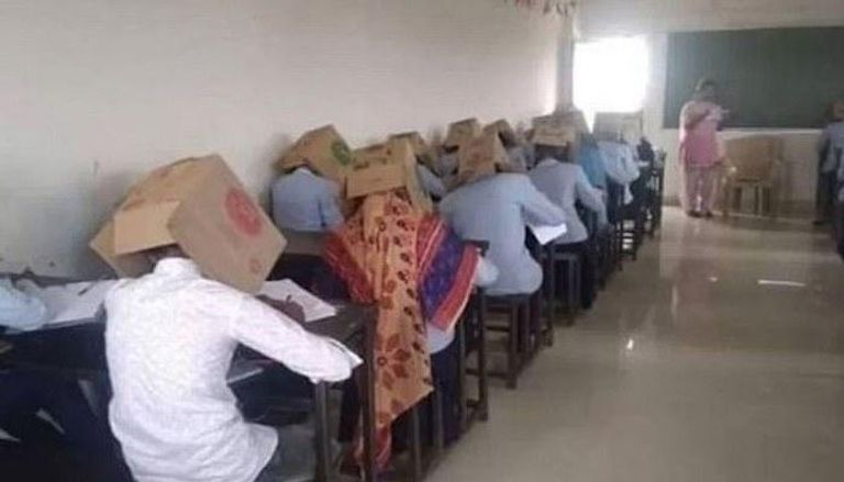 طلاب يضعون صناديق فوق رؤوسهم خلال أداء الامتحان