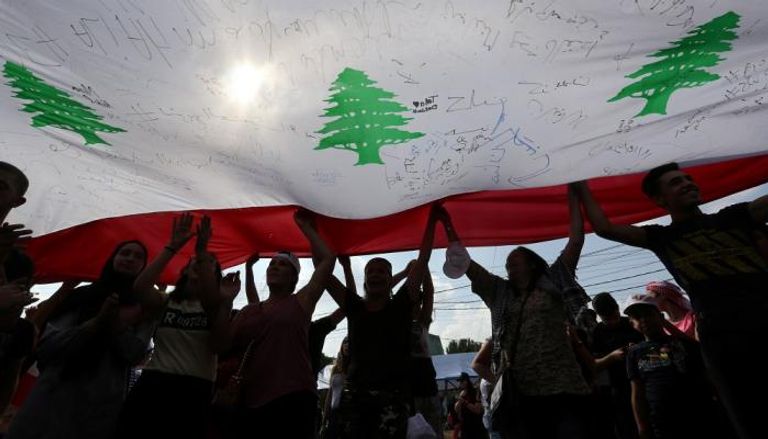 المتظاهرون يتجمعون تحت علم لبنان
