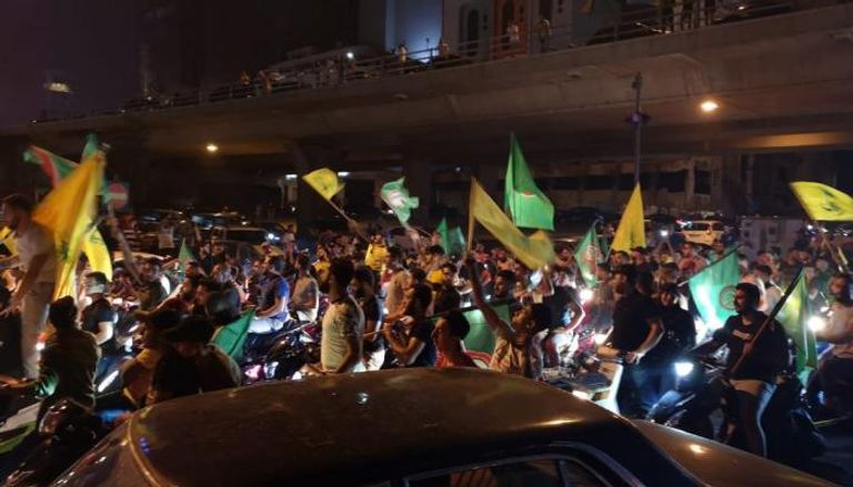 مجموعة من المتظاهرين يحملون أعلام حزب الله