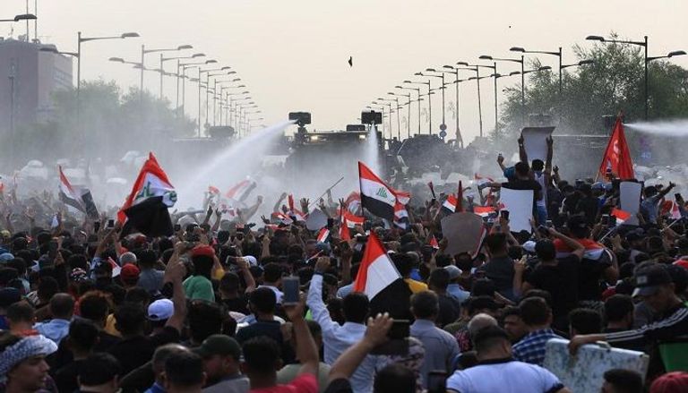 الشرطة العراقية تحاول فض مظاهرة لمحتجين - أرشيفية