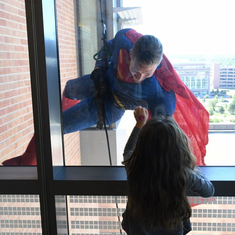 ضابط الشرطة المتنكر في زي باتمان يلوح للأطفال