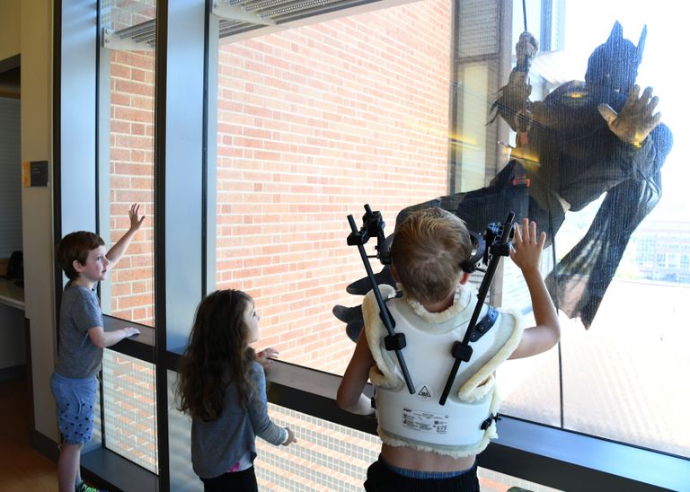 ضابط الشرطة المتنكر في زي باتمان يلوح للأطفال