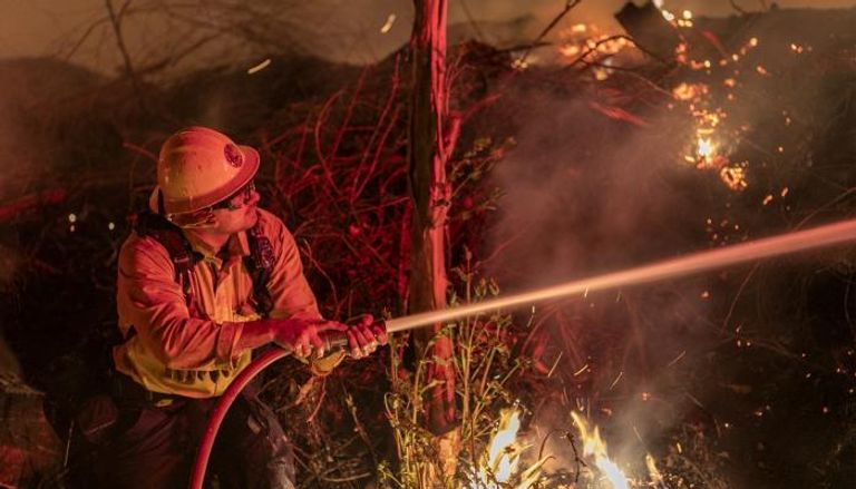 رجل إطفاء أمريكي يحاول مكافحة النيران المستعرة في غابات كاليفورنيا