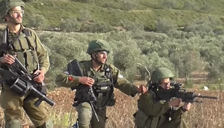جنود الاحتلال يصوبون أسلحتهم تجاه محتجين فلسطينيين - أرشيفية